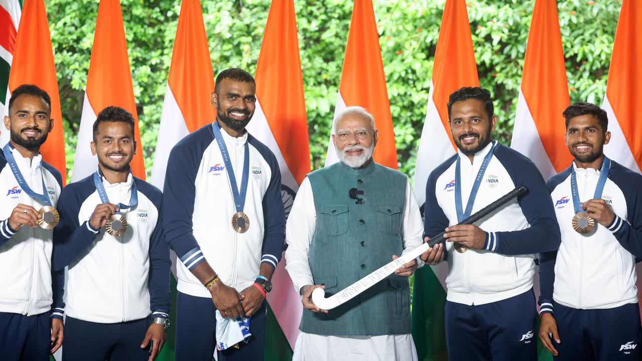 India's Hockey captain Harmanpreet Sigh presents PM Modi with a signed hockey stick by the entire team