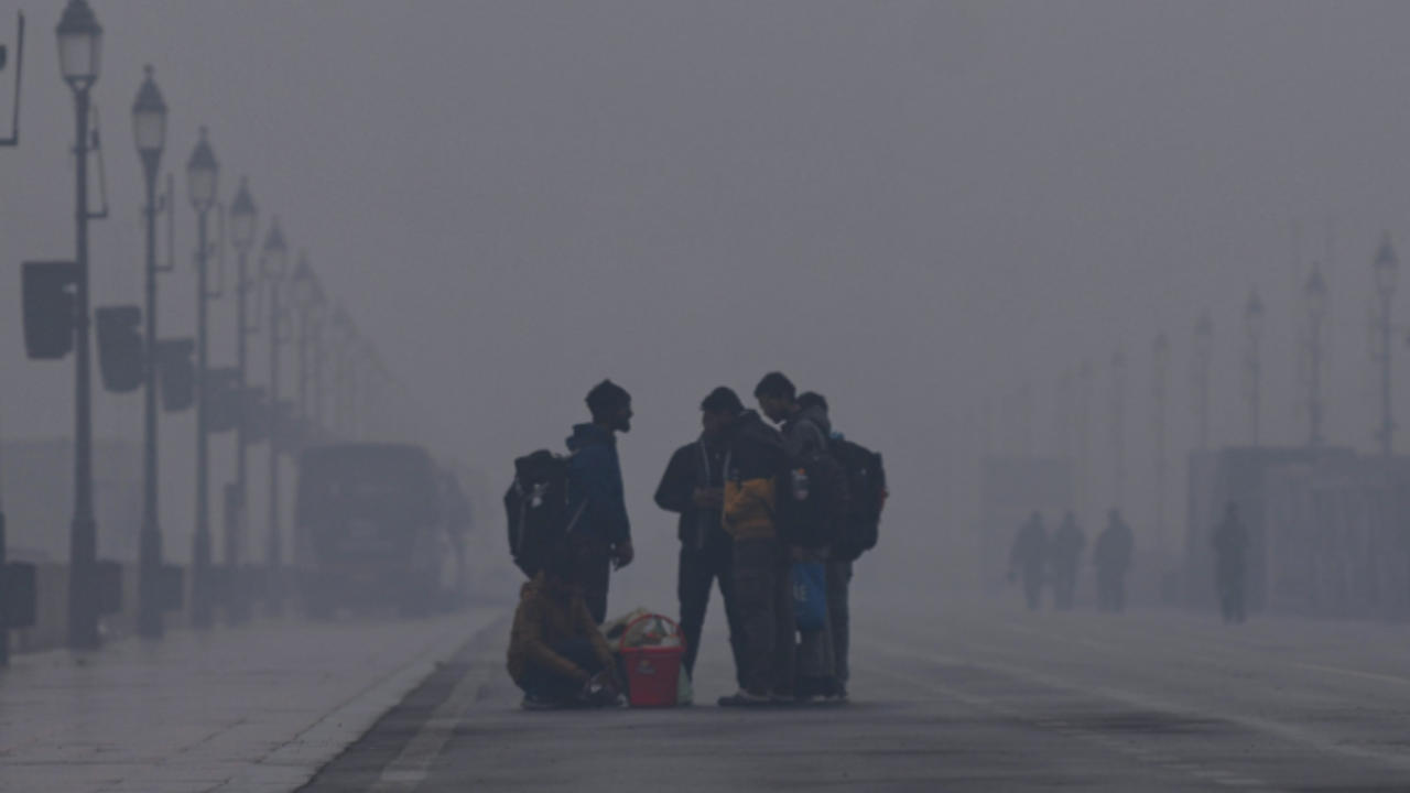 People seen on Kartavya Path amid the dense fog on a cold winter morning, in New Delhi 