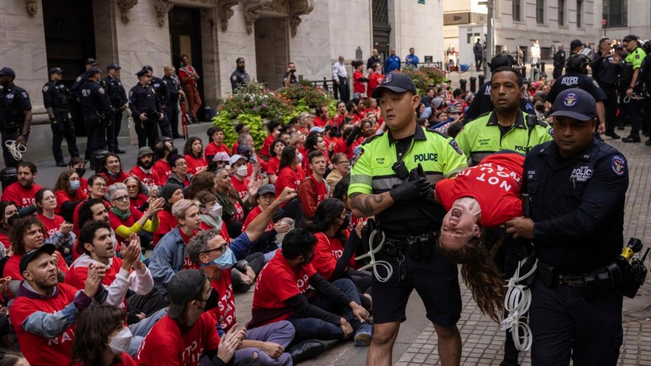 Police officers detain a demonstrator protesting Israel's war against Hamas  outside the New York Stock Exchange