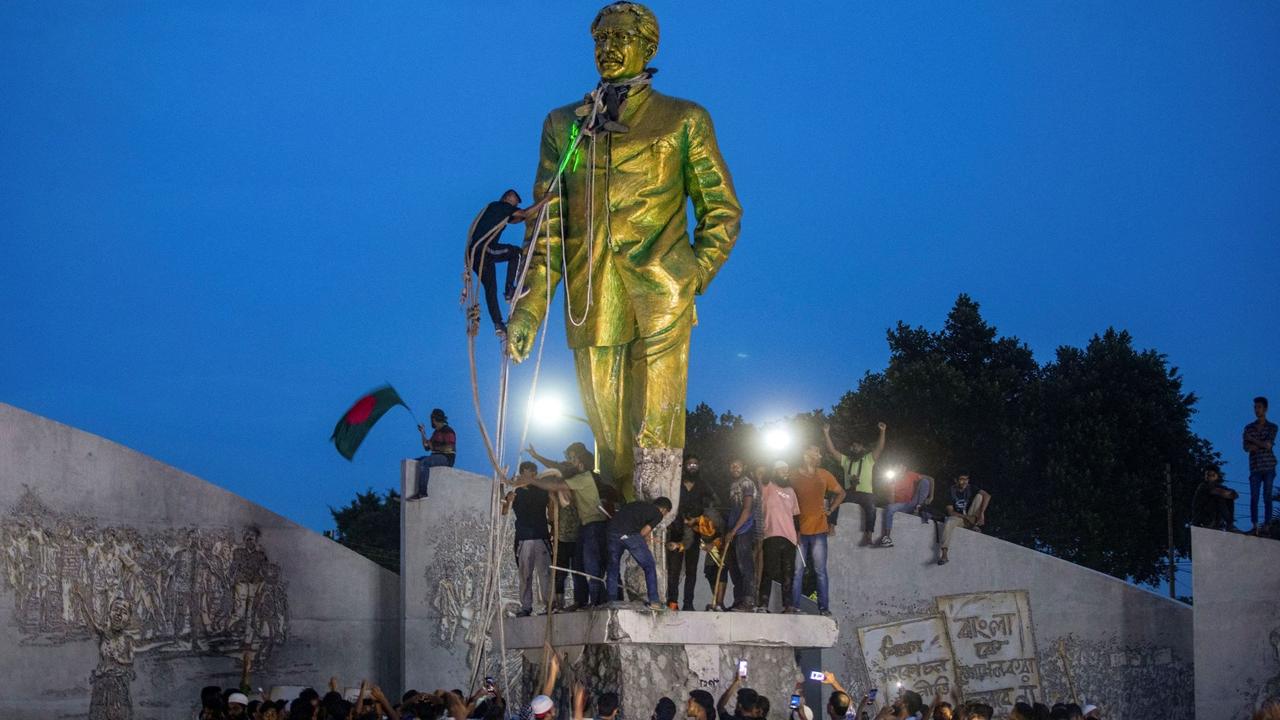 Protesters try to demolish a large statue of Sheikh Mujibur Rahman, father of Bangladesh leader Sheikh Hasina, after she resigned as Prime Minister, in Dhaka