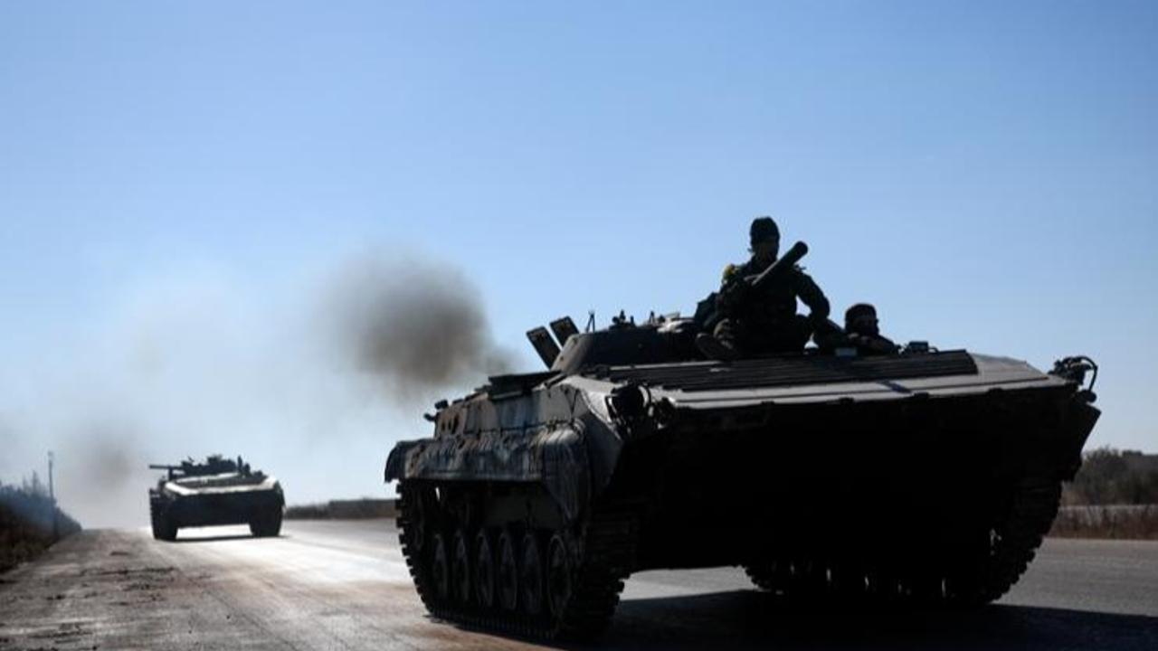 Syrian opposition fighters drive a seized Syrian army armored vehicle near the town of Khan Assubul, Syria, southwest of Aleppo