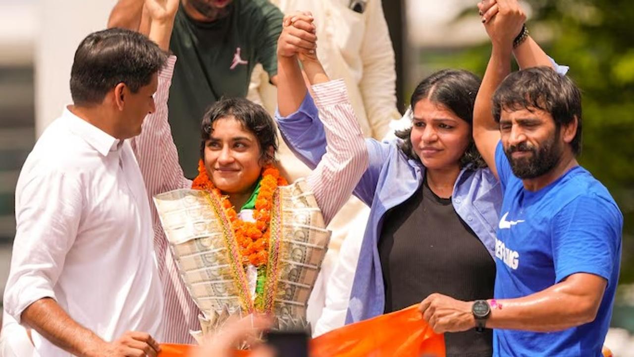 Wrestlers Bajrang Punia and Sakshi Malik celebrate alongside Vinesh Phogat as she returns to India