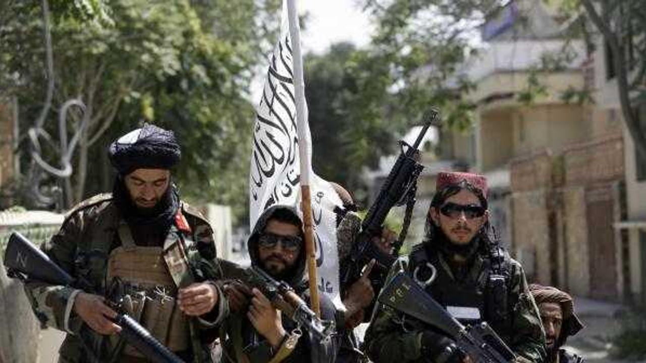 Taliban fighters display their flag on patrol in Kabul, Afghanistan