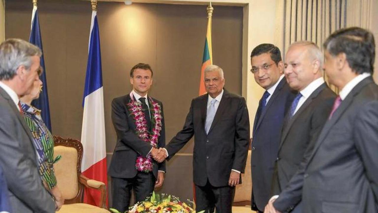 Sri Lankan President Ranil Wickermesinghe shakes hand with his French counterpart Emmanuel Macron during a meeting in Colombo