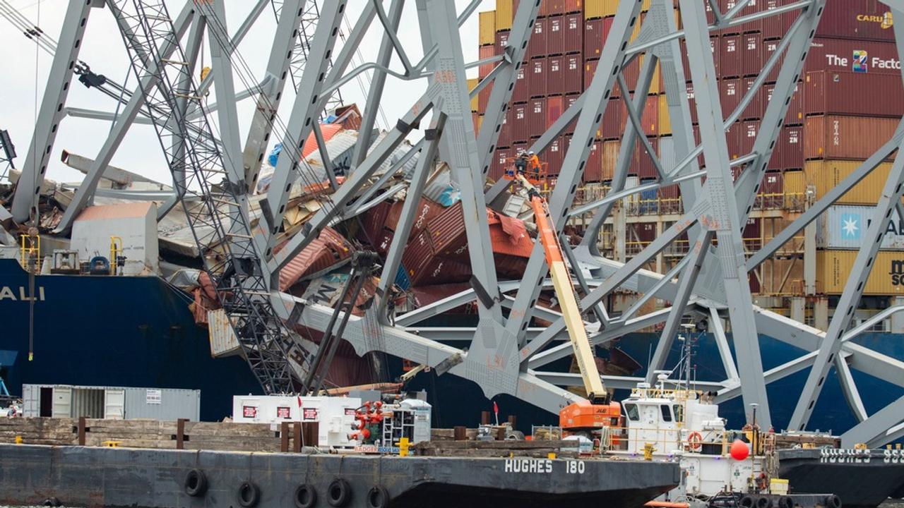 Cleanup crews rigging a section of the collapsed bridge with demolition charges. 