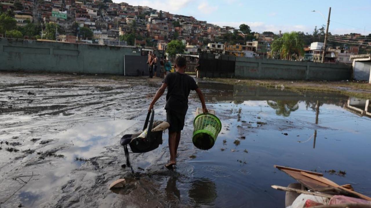 A child was seen collecting belongings in a flooded area after heavy rains hit Rio de Janeiro.