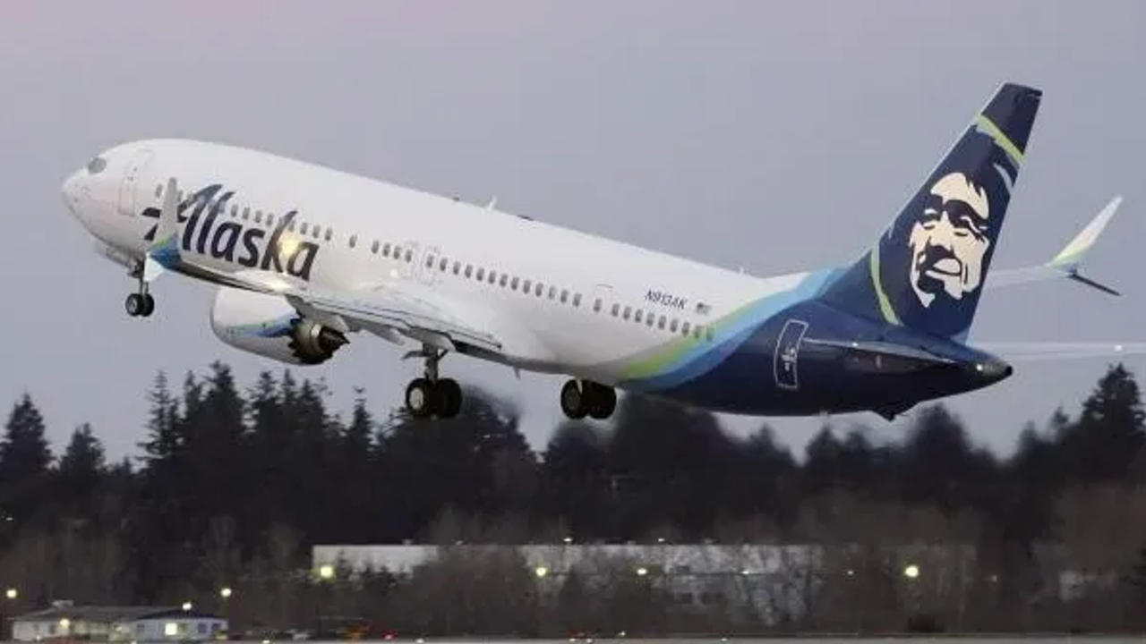  Alaska Airlines planes are shown parked at gates at sunrise