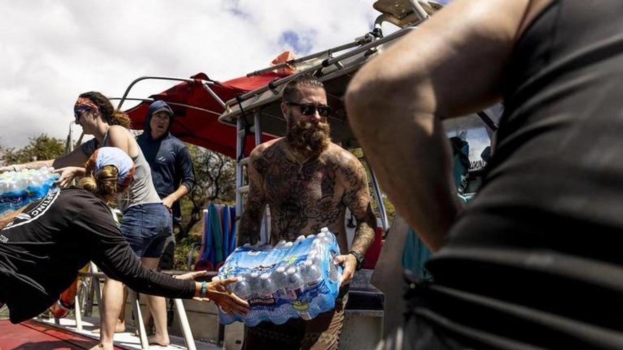 Volunteers load supplies onto a boat for West Maui at the Kihei boat landing, after a wildfire destroyed much of the historical town of Lahaina (Imag