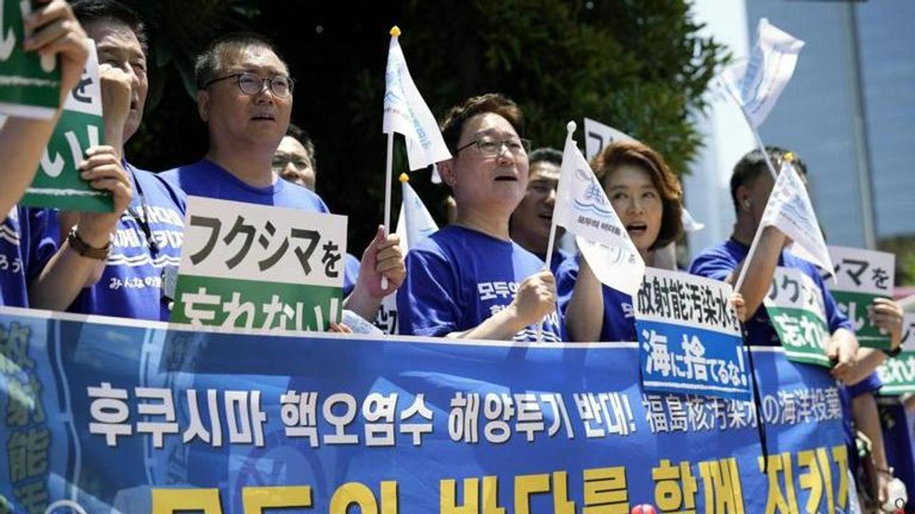 South Korean lawmakers hold placards and a banner against Japanese plans to release treated radioactive water from the damaged Fukushima nuclear power