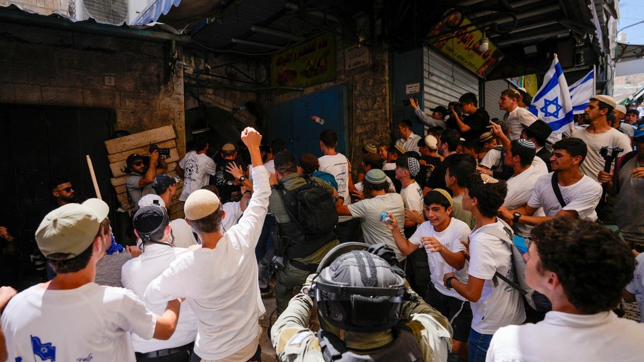 Israeli police officers separate Israelis and Palestinians in a street in Jerusalem's Old City, shortly before a march through the area by Jewish nationalists in Jerusalem Day on June 5, 2024. 