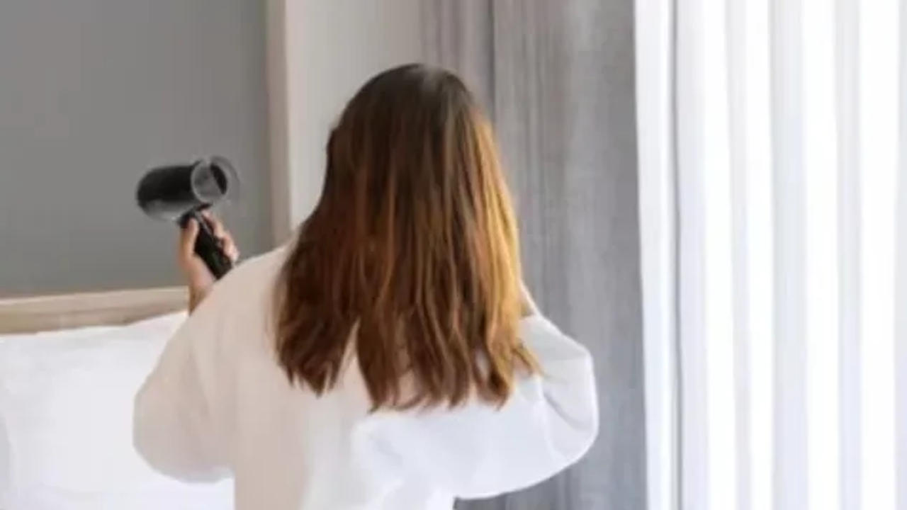  Woman using hairdyer at Hotel 