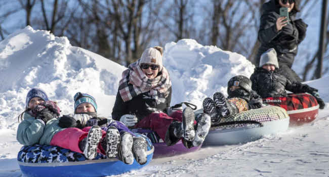 (Friends and family enjoy a fun morning tubing down the hill behind Sherwood Heights Elementary School Auburn, Maine, Monday, Jan. 20, 2025.