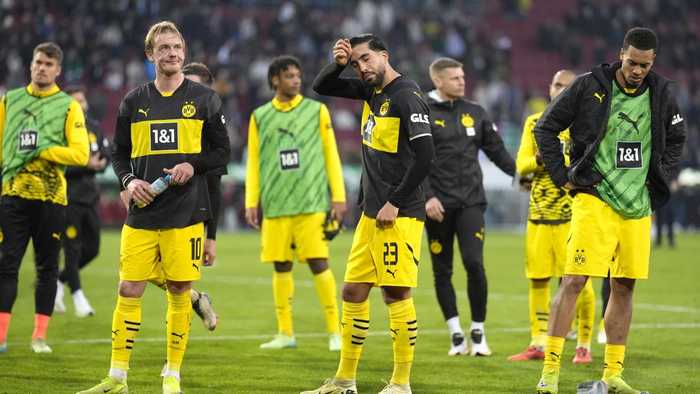 Dortmund holds on with 10 men for 1st away win in Bundesliga