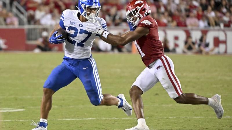 BYU running back LJ Martin (27) tries to get past Arkansas defensive back 