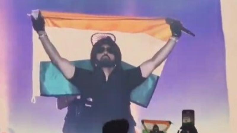 Diljit Dosanjh holding Indian flag at Delhi concert.