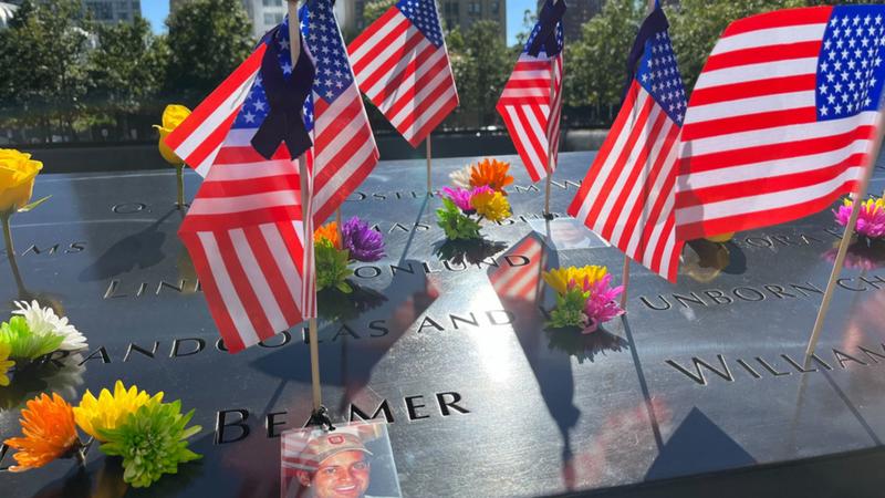 Flags and flowers are placed by the names of those killed during 9/11 attacks 