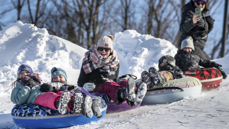 (Friends and family enjoy a fun morning tubing down the hill behind Sherwood Heights Elementary School Auburn, Maine, Monday, Jan. 20, 2025.