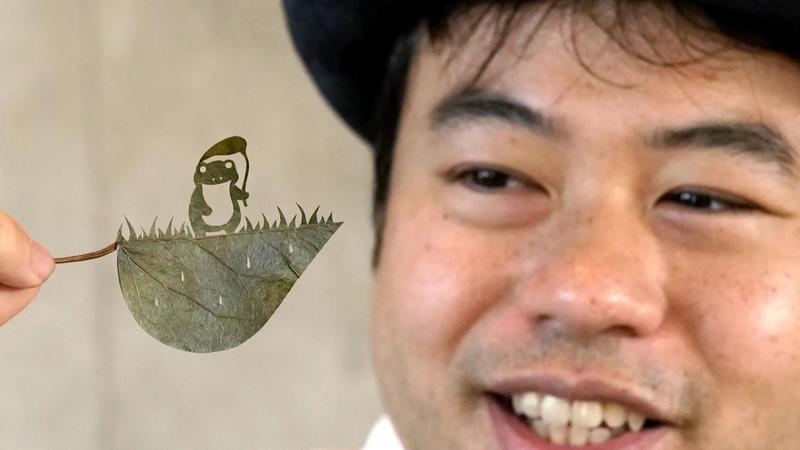 Japanese artist Lito adores his latest creation, a frog holding a taro-leaf umbrella.