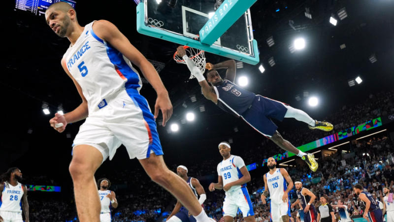 LeBron James dunks over France's Nicolas Batum during the Paris Olympics gold medal match