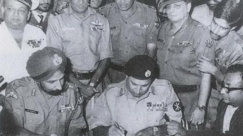 Lt Gen AAK Niazi of the Pakistan Army signing the Instrument of Surrender under the direction of Lt. Gen. Jagjit Singh Aurora of Indian Army