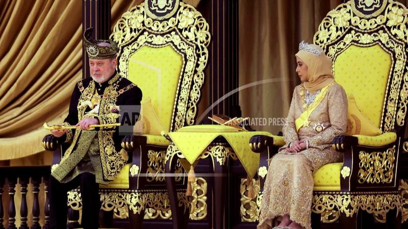 The 17th King of Malaysia, Sultan Ibrahim Iskandar, left, lifts a ceremonial dagger as Queen Raja Zarith Sofiah looks on during his coronation at the National Palace in Kuala Lumpur, Malaysia, Saturday