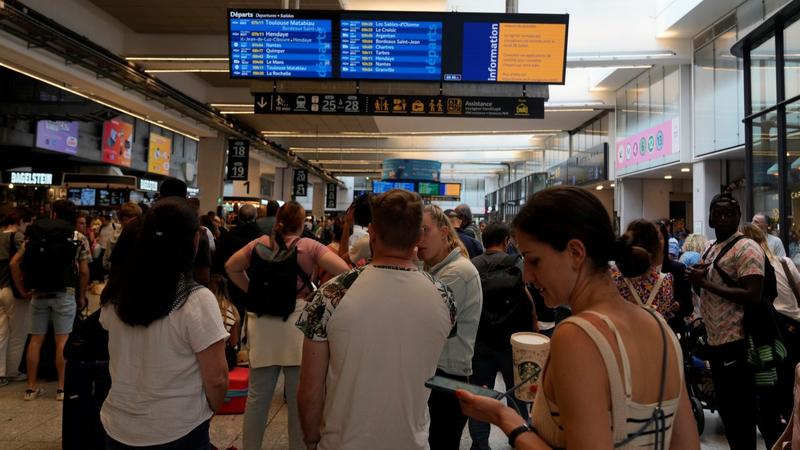 Travelers check trains on an electronic board at the Gare de Montparnasse, at the 2024 Summer Olympics.