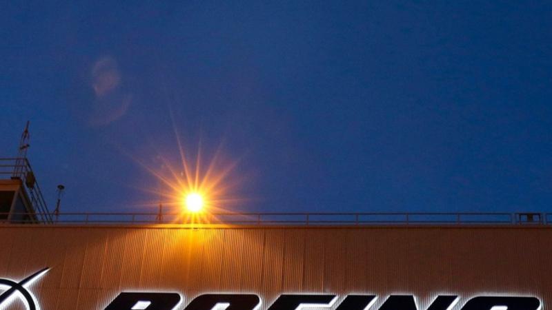 An airplane flies over a sign on Boeing's newly expanded 737 delivery center, Oct. 19, 2015, at Boeing Field in Seattle. (AP Photo)