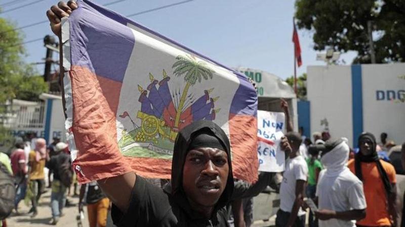 A demonstrator holds up a Haitian flag during a protest against insecurity in Port-au-Prince, Haiti