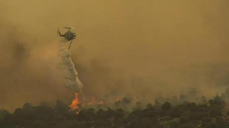 A firefighting helicopter tackles the wildfires in Greece. Image: AP