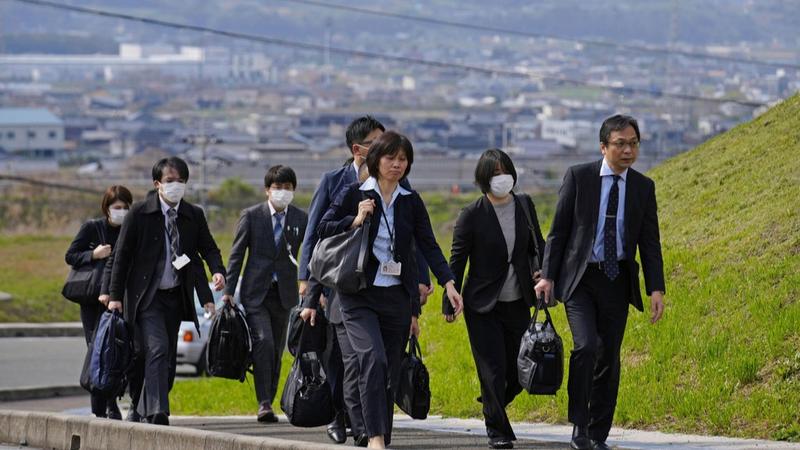 Japanese government officials arriving for the inspection of a factory belonging to Kobayashi Pharmaceutical Co.