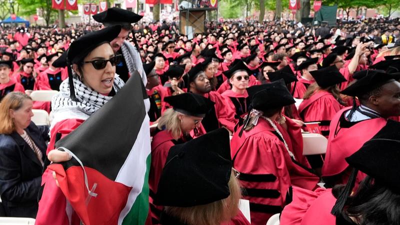 Graduating students chant as they depart commencement in protest to the 13 graduating seniors who were not allowed to participate due to protest activities.