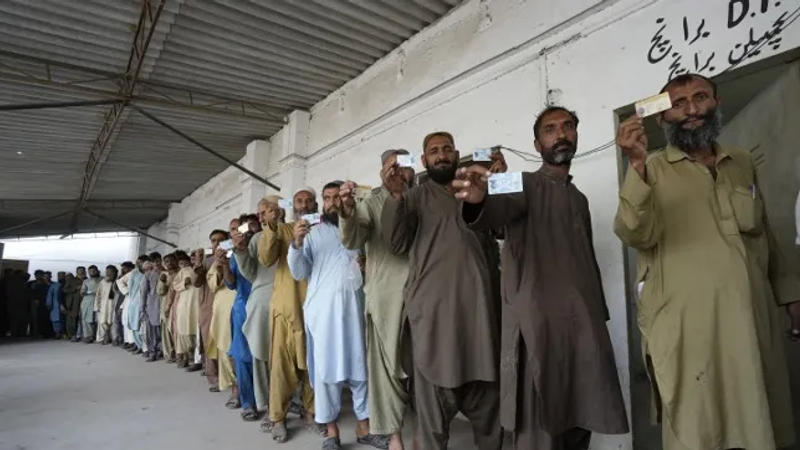 Immigrants, mostly Afghans, show their ID cards as they wait their turn to verify data at a counter of Pakistan’s National Database and Registration Authority, in Karachi, Pakistan