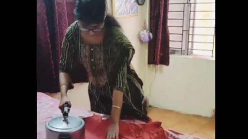 Woman Using Pressure Cooker To Iron Clothes