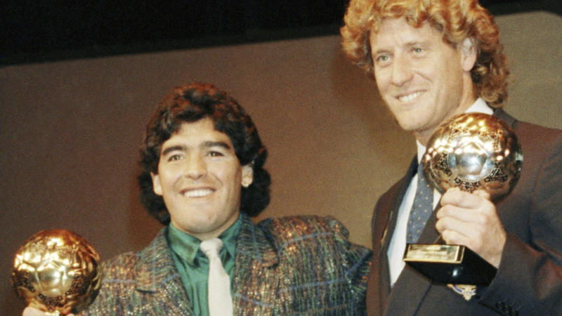 Diego Maradona (l) and Harald Schumacher (R) hold their World Cup Golden Ball trophy