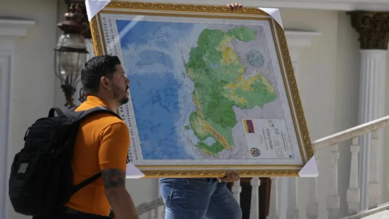 A man carries the new map of Venezuela with the Essequibo territory.