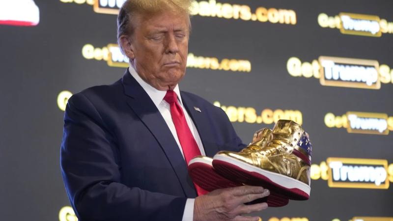 Former US President Donald Trump holds sneakers at Sneaker Con in Philadelphia