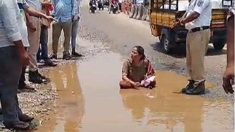 Woman sits in water-filled pothole to protest against bad roads in Hyderabad
