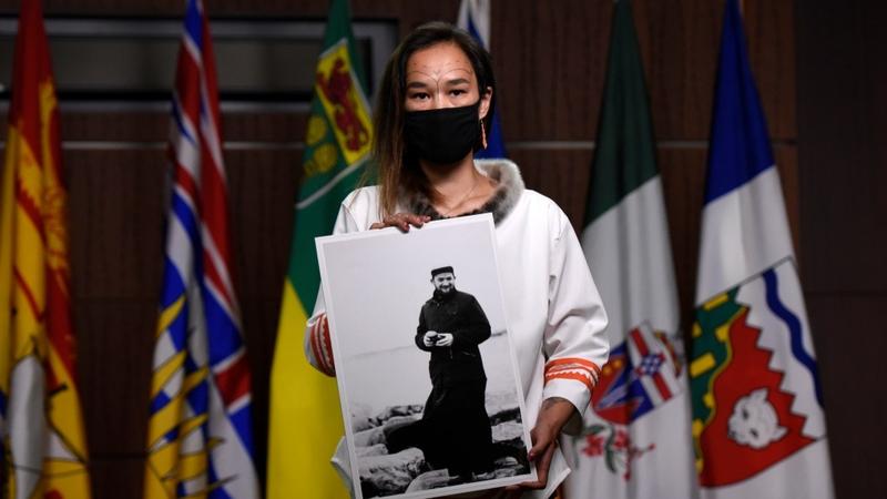 An Inuit woman holding an image of the "Devil priest". 