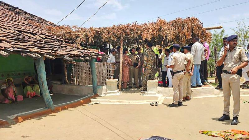 Police personnel investigate the crime scene after a youth hacked to death eight members of his family and then committed suicide in tribal village of Bodal Kachhar, in Chhindwara. 