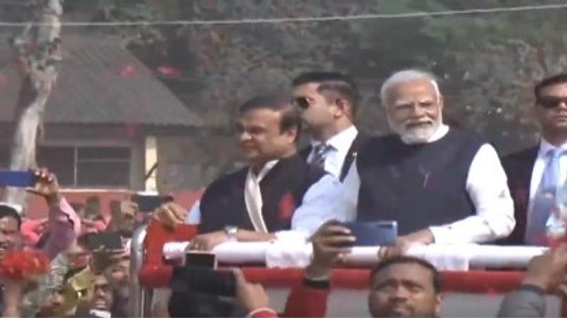 PM Narendra Modi along with Assam CM Himanta Biswa Sarma greets people gathered at the public event