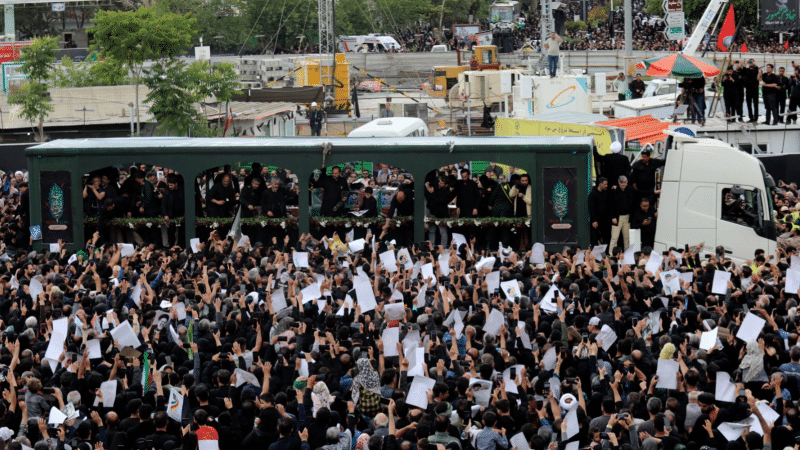 Mourners surround a truck carrying the flag-draped coffins of the President Ebrahim Raisi, and his companions who were killed in a helicopter crash, during their funeral ceremony in Mashhad, May 23, 2024.