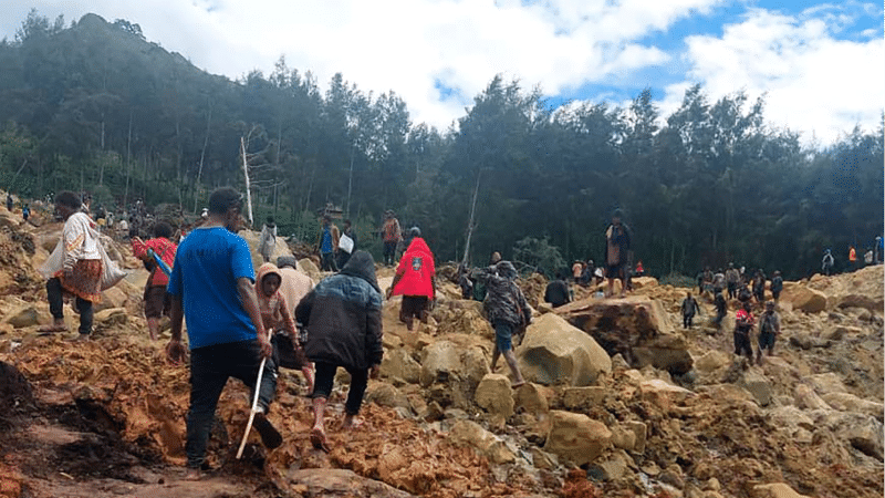 People cross over the landslide area to get to the other side in Yambali village, Papua New Guinea, May 24, 2024.