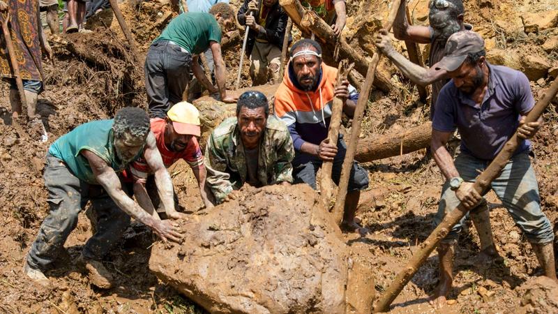 In this photo released by UNDP Papua New Guinea, villagers search through a landslide in Yambali village, in the Highlands of Papua New Guinea, May 27, 2024. 